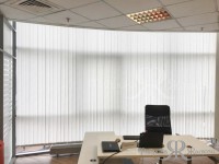 Белые вертикальные жалюзи на панорамном окне в офисе